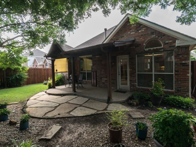 Another view of the covered patio and rear of this gorgeous backyard. | Image 35
