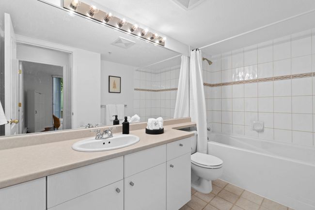 Bathroom featuring shower / tub combo, vanity, toilet, and tile patterned flooring | Image 12