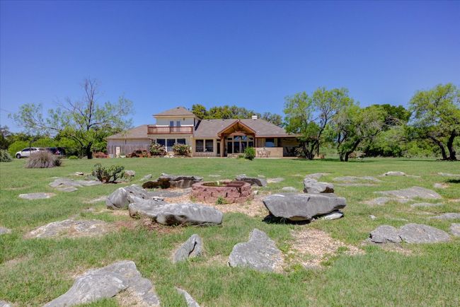 View of the backyard featuring a fire pit. | Image 28