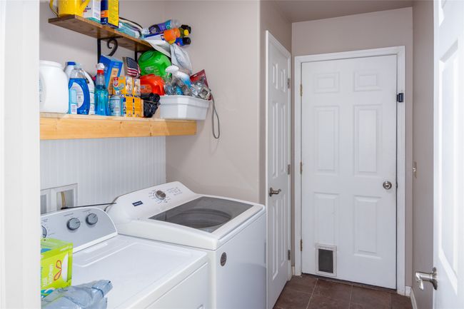 Laundry area featuring independent washer and dryer, laundry area, dark tile patterned floors, and visible vents | Image 52