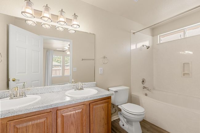 Full bath with double vanity, wood finished floors, and washtub / shower combination | Image 20