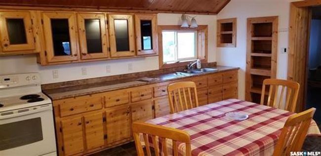 Kitchen with wooden ceiling, sink, lofted ceiling, and white electric stove | Image 13