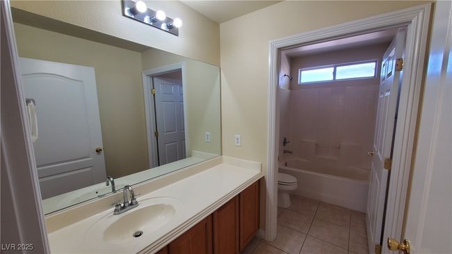Full bathroom with toilet, tile patterned flooring, vanity, and shower / washtub combination | Image 17