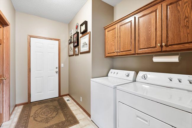 Functional mudroom/laundry room with oak cabinets for extra storage and direct access to the attached garage—perfect for everyday convenience. | Image 32