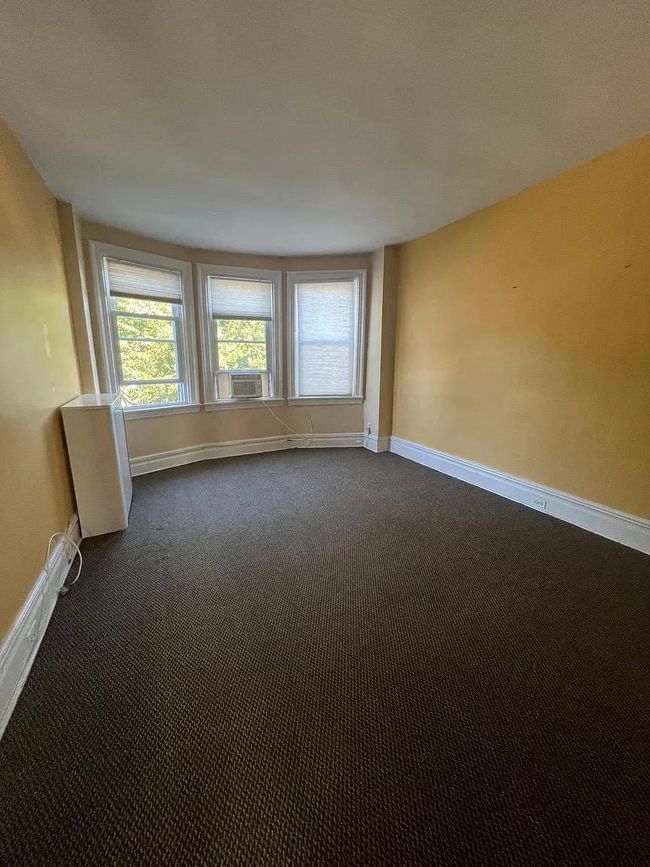 Unfurnished room with dark colored carpet and cooling unit | Image 4
