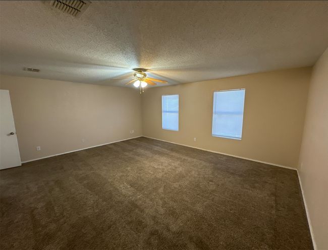Carpeted spare room with ceiling fan and a textured ceiling | Image 21