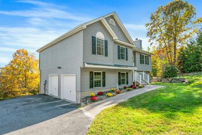 View of bilevel home with a garage and a front lawn | Image 2