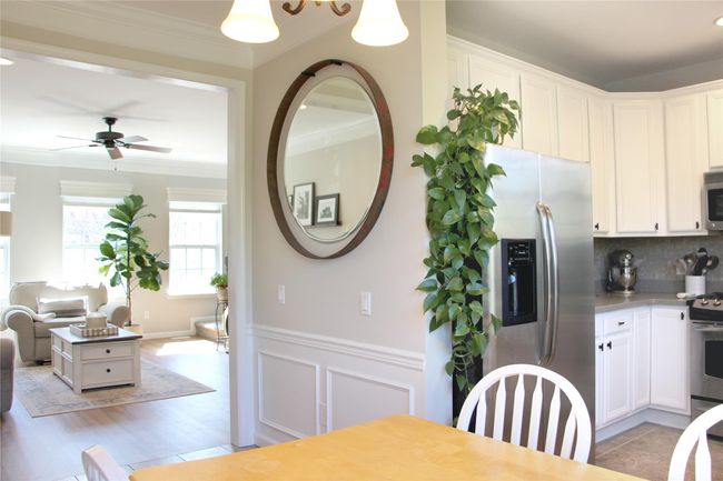 Dining area with crown molding, a decorative wall, a ceiling fan, and a wainscoted wall | Image 10