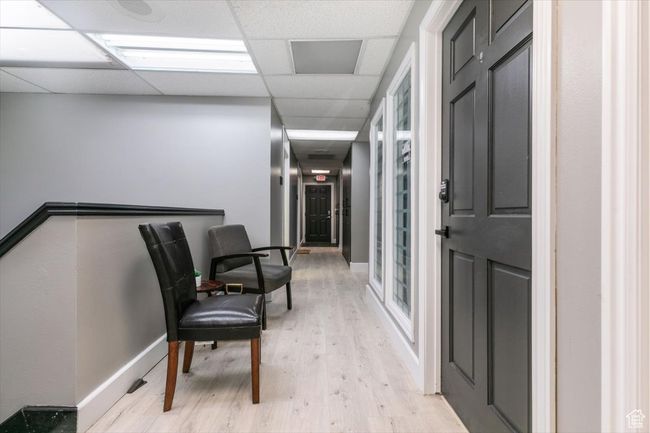Hallway with light wood-style floors and a drop ceiling | Image 18