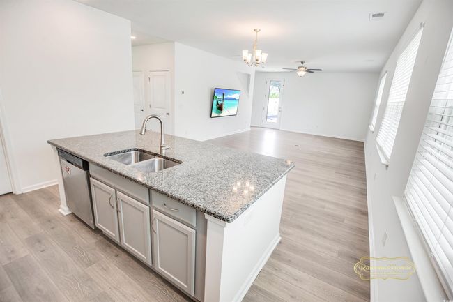Kitchen featuring dishwasher, a kitchen island with sink, a sink, a chandelier, and gray cabinets | Image 12