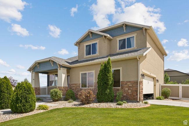 Craftsman-style house with stucco siding, stone siding, a garage, and concrete driveway | Image 4