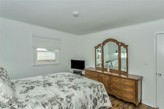 Bedroom with dark wood-style flooring and ornamental molding | Image 19