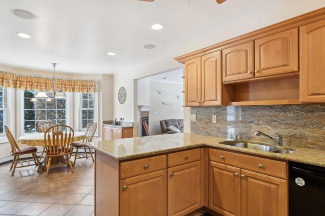 Kitchen with pendant lighting, sink, dishwasher, light stone countertops, and kitchen peninsula | Image 6