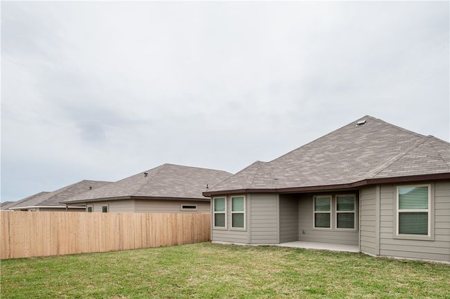 Rear view of house featuring a patio, a yard, fence, and roof with shingles | Image 22