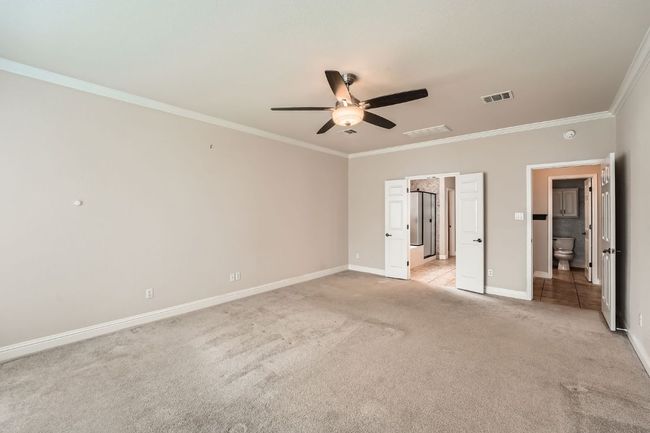 Unfurnished bedroom featuring visible vents, crown molding, light carpet, baseboards, and ceiling fan | Image 20
