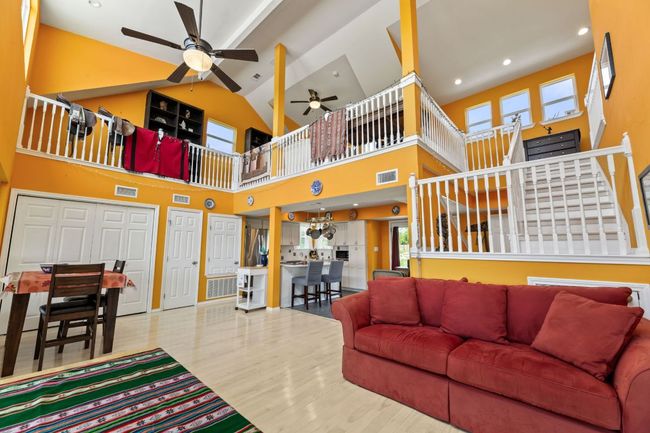 Living room with wood finished floors, visible vents, a healthy amount of sunlight, and ceiling fan | Image 14