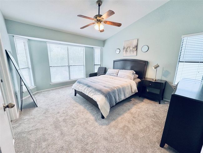 Carpeted bedroom featuring vaulted ceiling, ceiling fan, and baseboards | Image 17