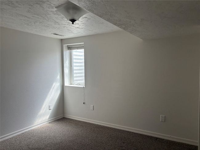 Carpeted empty room featuring a textured ceiling and baseboards | Image 23