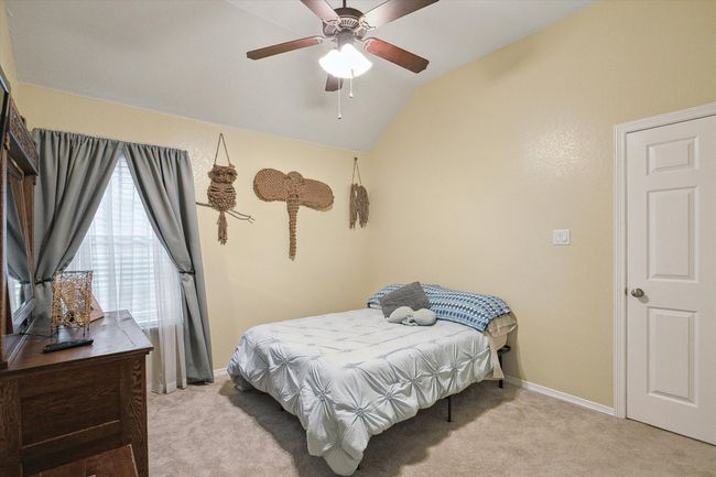 Secondary bedroom featuring light carpet, lofted ceiling, baseboards, and ceiling​​‌​​​​‌​​‌‌​‌‌​​​‌‌​​‌‌​‌​​​​​‌ fan | Image 17