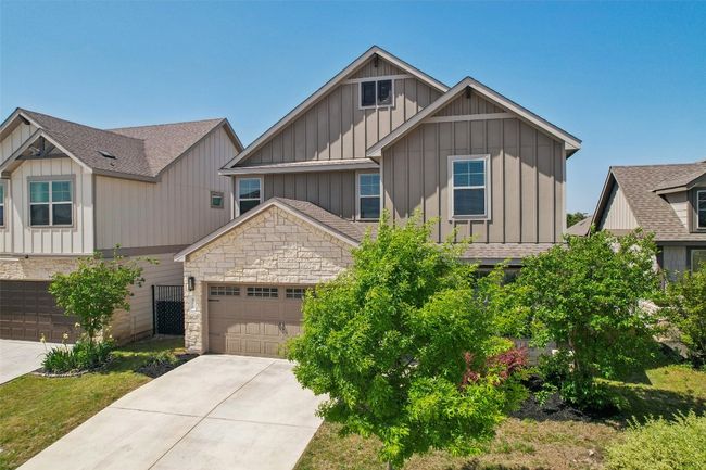 Craftsman-style house featuring concrete driveway, board and batten siding, stone siding, and an attached garage | Image 5