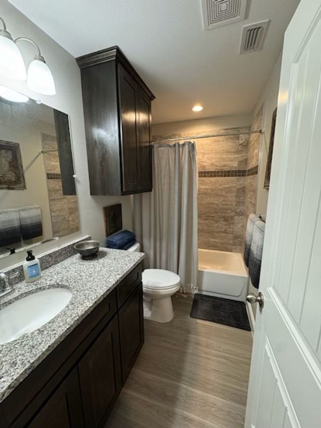 Full bathroom featuring visible vents, toilet, vanity, and wood finished floors | Image 5