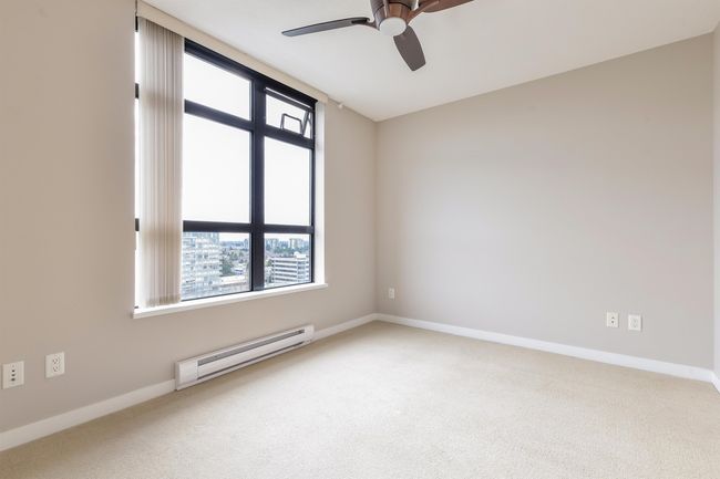 Carpeted empty room featuring baseboard heating, ceiling fan, and healthy amount of natural light | Image 22