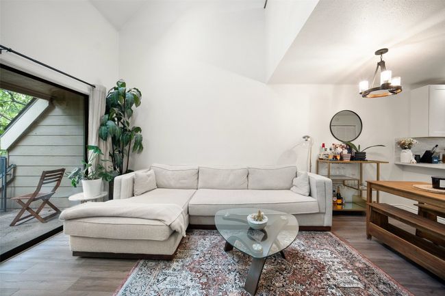 Open Concept Living Room with outdoor balcony and wood floors + vaulted ceilings. | Image 7