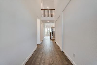 Corridor with a towering ceiling and dark hardwood / wood-style flooring | Image 2