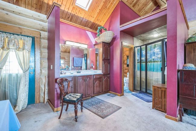 Full bathroom with wood ceiling, a skylight, vanity, lofted ceiling, and baseboards | Image 40