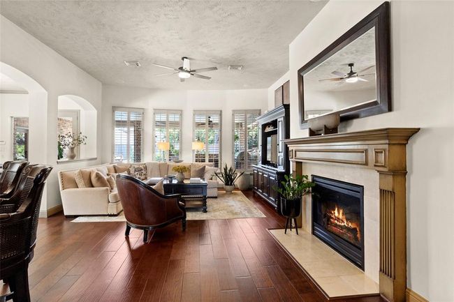 Family room has engineered wood flooring, gaslog fireplace and a wall of windows overlooking the backyard. | Image 8