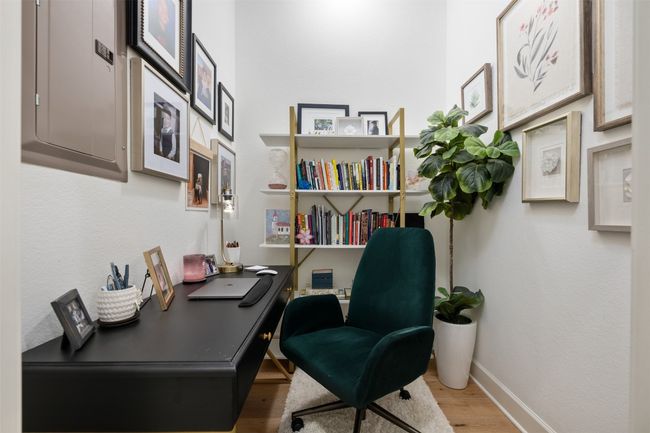 Cozy office with light wood finished floors, baseboards, and electric panel | Image 21