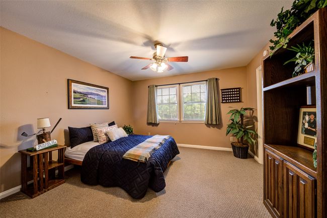 Bedroom with light colored carpet and a ceiling fan | Image 25