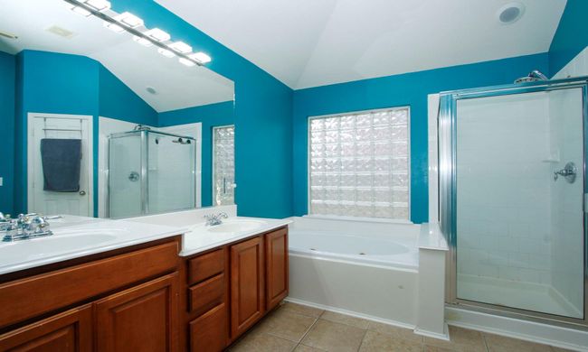 Primary bath with his and her sinks, a jetted tub and separate shower. | Image 11