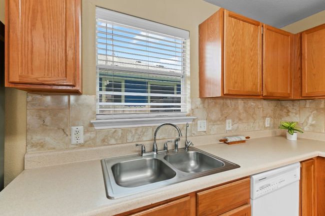 Kitchen with dishwasher, light countertops, backsplash, and brown cabinets | Image 19