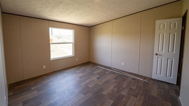 Empty room featuring a textured ceiling and wood finished floors | Image 17