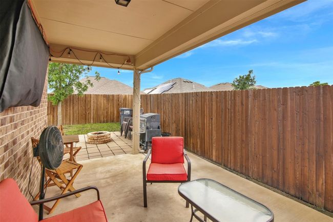Fenced backyard featuring a fire pit, a patio area, and a grill | Image 24