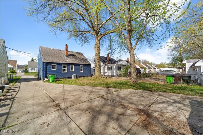 Rear view of house with a residential view, a chimney, driveway, and a shingled roof | Image 12