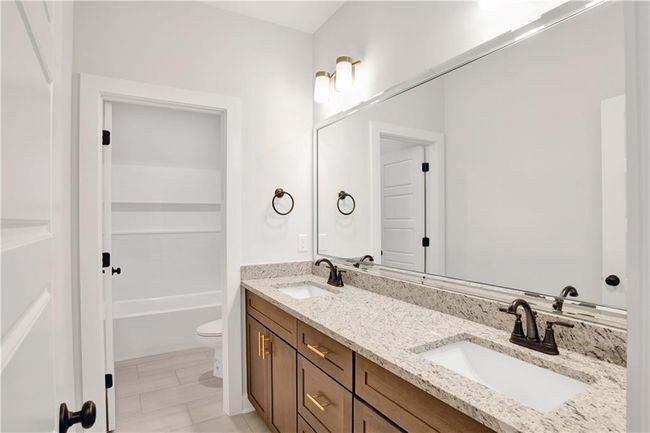 Full bath featuring double vanity, toilet, a washtub, and a sink | Image 21