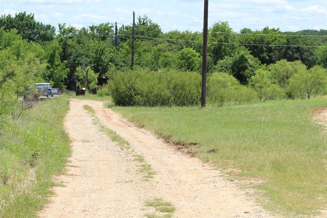 View of dirt / gravel road with a view of trees | Image 8