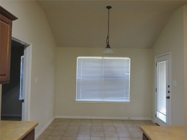 Unfurnished dining area featuring vaulted ceiling, light tile patterned floors, and baseboards | Image 7