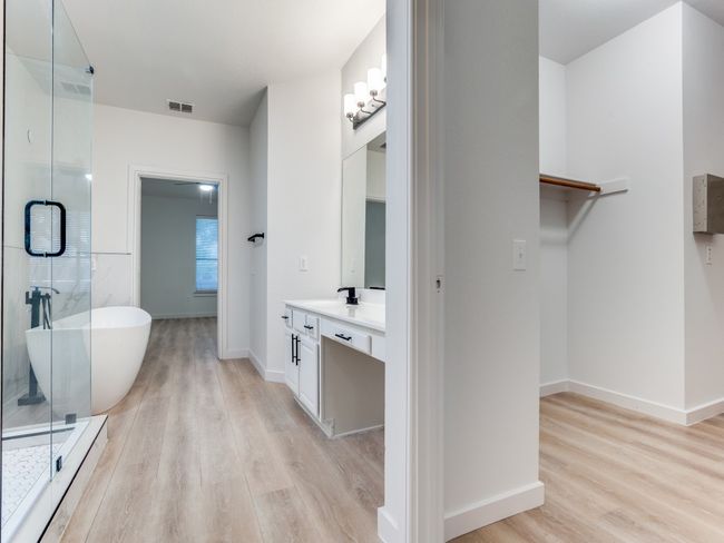 Full bath featuring wood finished floors, vanity, a freestanding tub, and a stall shower | Image 19