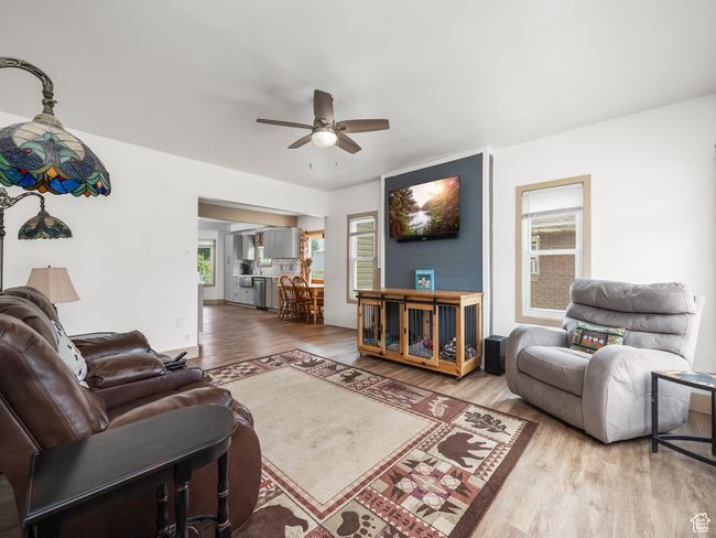 Living area with a ceiling fan and wood finished floors | Image 21