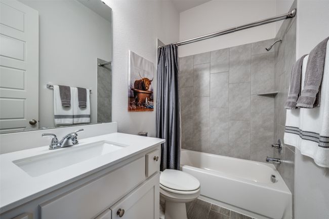 Full bathroom featuring shower / bath combination with curtain, toilet, vanity, and wood finished floors | Image 20