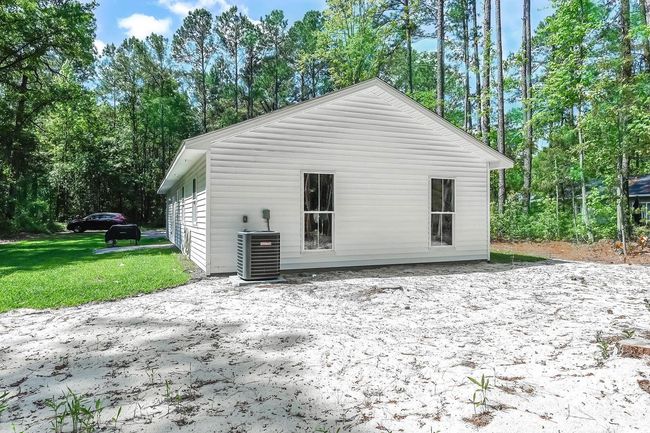 Rear view of house with central air condition unit and a yard | Image 24