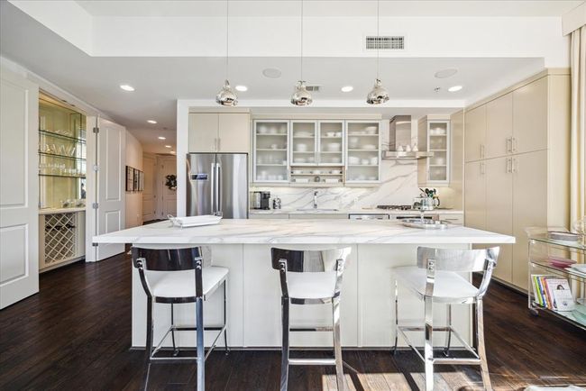 This shows the kitchen and to the left a bar area with wine storage. | Image 12