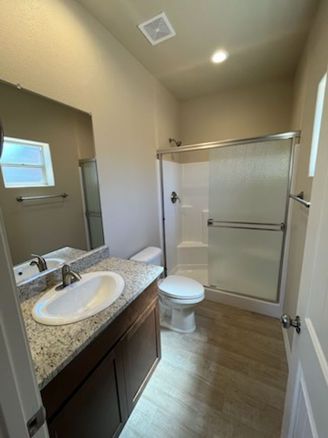 Bathroom with a stall shower, wood finished floors, vanity, toilet, and recessed lighting | Image 22