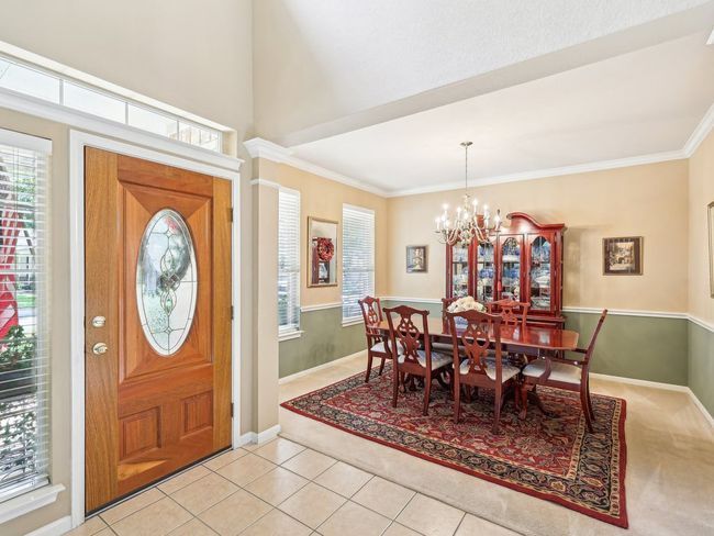 Foyer entrance featuring healthy amount of natural light, a chandelier, crown molding, baseboards, and light tile patterned floors | Image 12