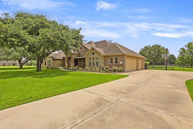An extra-wide driveway leads to the home’s 3-car garage, and also provides a safe place to shoot hoops, ride bikes, or skip rope. The extension at the end of the driveway also offers space for additional parking when entertaining. | Image 4