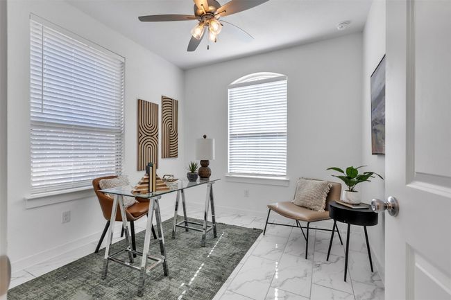 Home office with marble look tile flooring and ceiling fan | Image 5