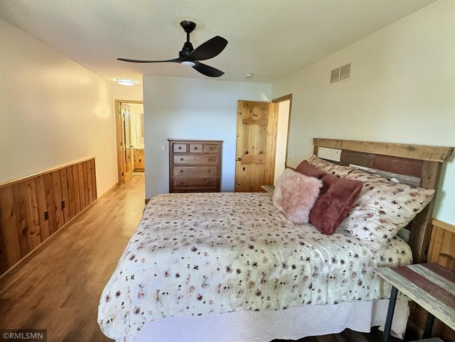 The primary suite is complete with ceiling fan, wood accents, walk-in closet, and wonderful natural light. | Image 19